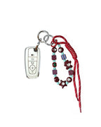 White Ford car key fob cover case with pastel plaid heart design, paired with a handmade beaded keychain featuring cute patterned beads, and a red braided cord on a white background.