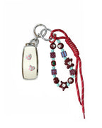 White Mercedes Benz car key fob cover case with pastel plaid heart design, paired with a handmade beaded keychain featuring cute patterned beads, and a red braided cord on a white background.