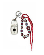 White Mercedes Benz car key fob cover case with pastel plaid heart design, paired with a handmade beaded keychain featuring cute patterned beads, and a red braided cord on a white background.