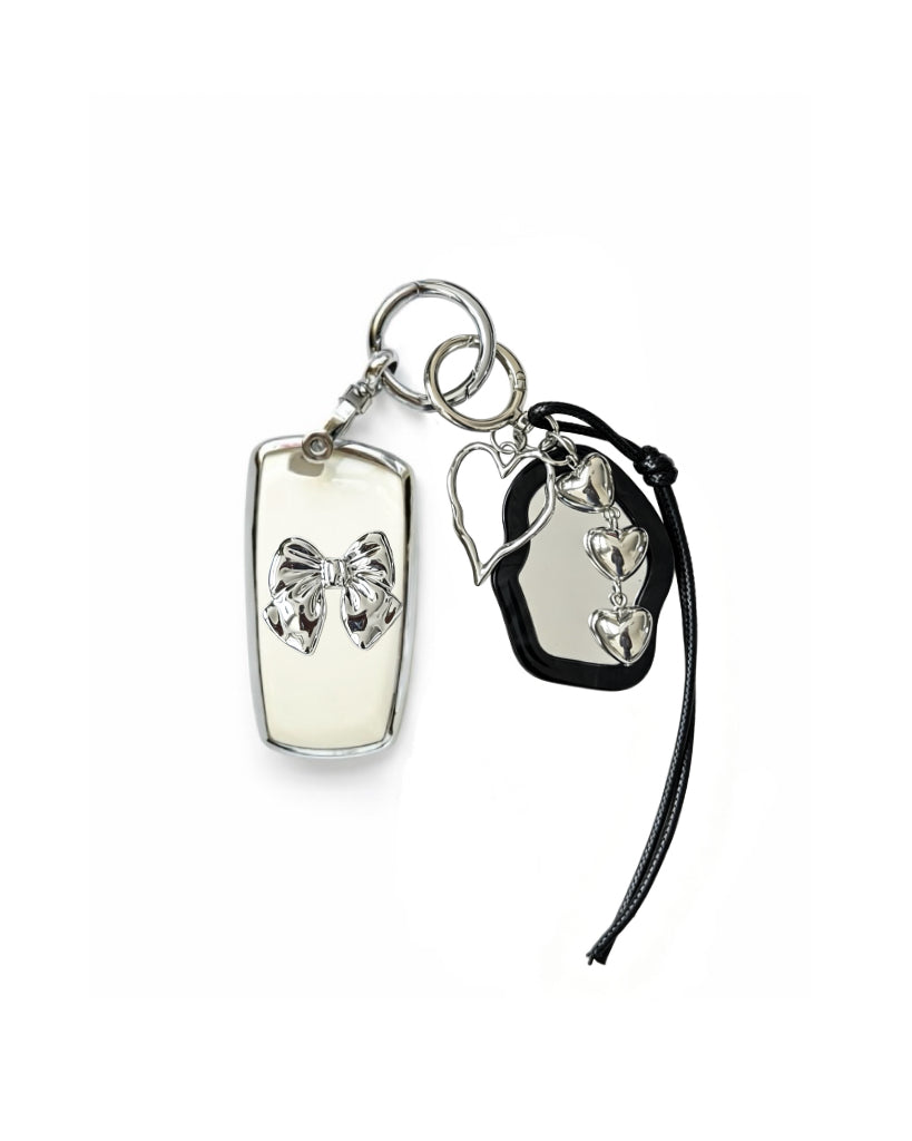 White Bmw key fob case with black mirror and silver bow keychain