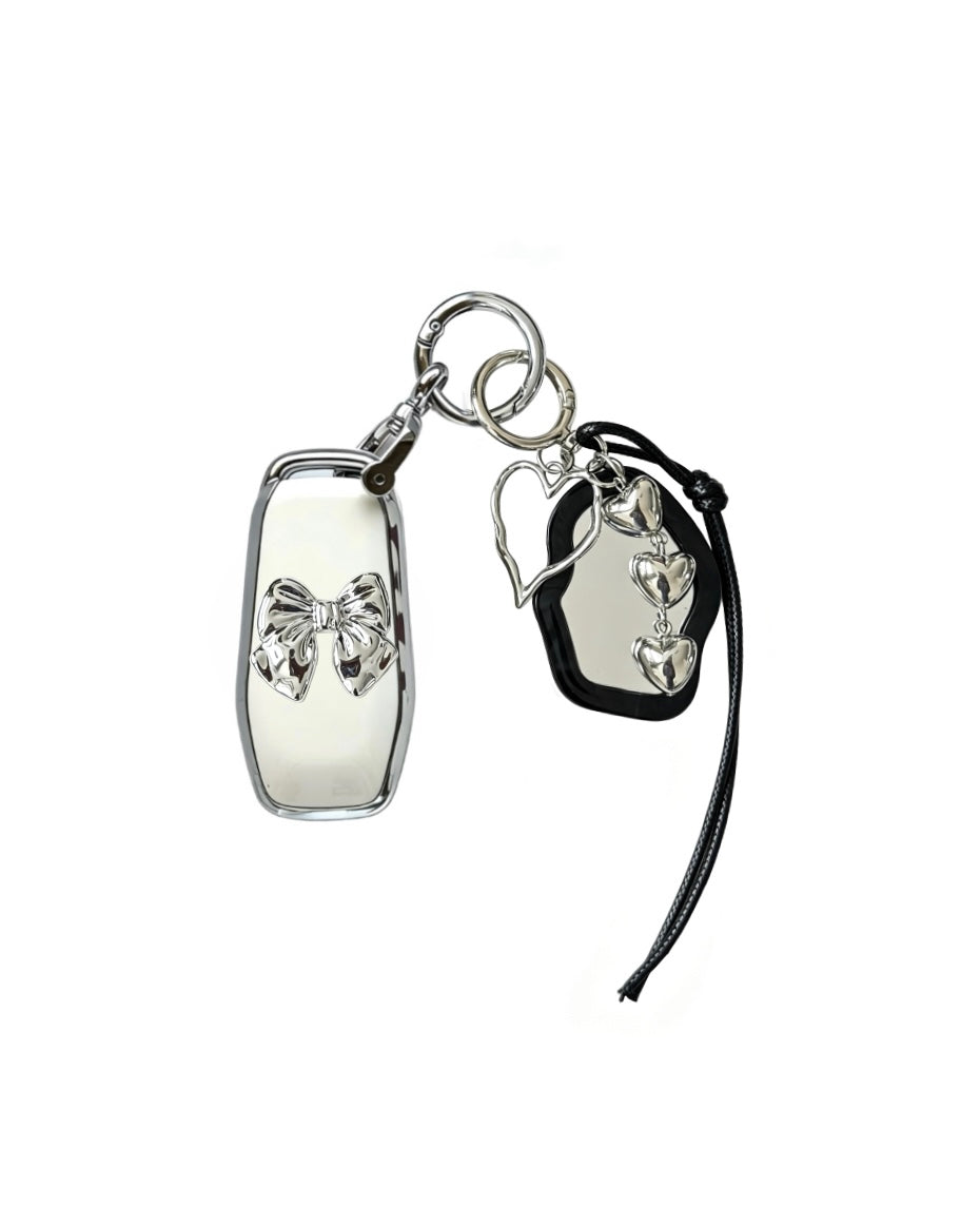 White Ford key fob case with black mirror and silver bow keychain