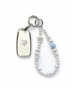 White Chevrolet key fob cover case with a pearl heart on the back, paired with a pearl white beaded wrist strap key chain featuring a blue accent bead and star charm, displayed on a white background.
