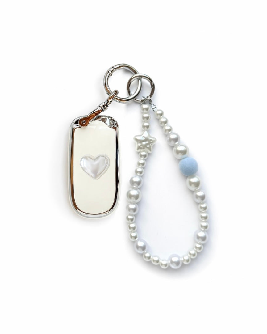 White Jeep key fob cover case with a pearl heart on the back, paired with a pearl white beaded wrist strap key chain featuring a blue accent bead and star charm, displayed on a white background.